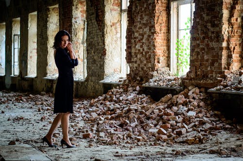 黑色礼服站在堆砖头的女人 · 免费素材图片