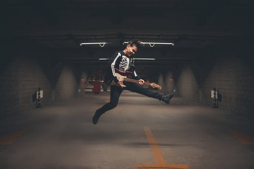 白色和红色的球衣衬衫和黑色的裤子，在灰色的水泥地板上跳跃的人 · 免费素材图片