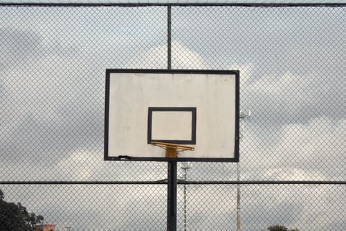 旋风栅栏附近的篮球筐照片 · 免费素材图片