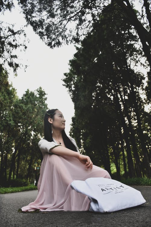 女人坐在柏油路的照片 · 免费素材图片