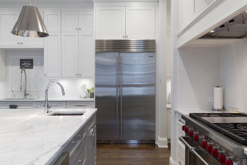 白色厨房柜子旁边的不锈钢冰箱 · 免费素材图片
