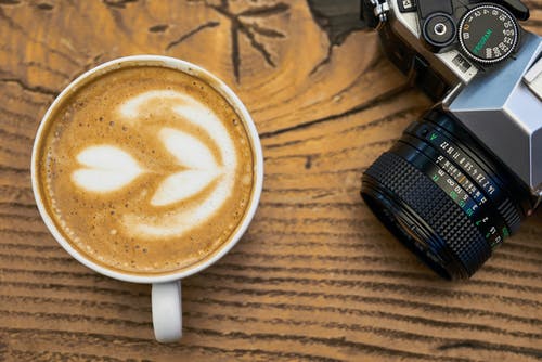 咖啡在相机附近的特写照片 · 免费素材图片