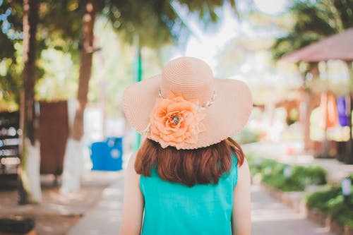 女人在桃红色的太阳帽和蓝色上衣的背影照片 · 免费素材图片