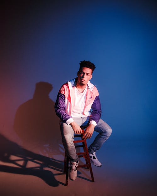 男子坐在棕色凳子上 · 免费素材图片