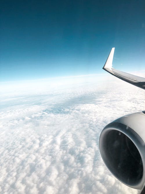 飞机在云层上方飞行的照片 · 免费素材图片