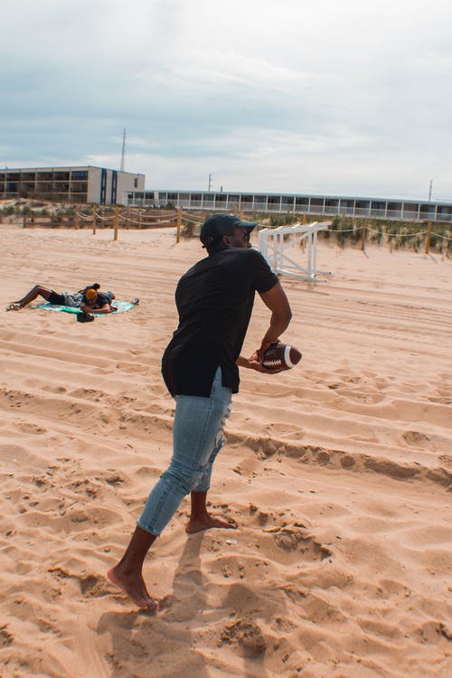 在沙滩上踢足球的人 · 免费素材图片