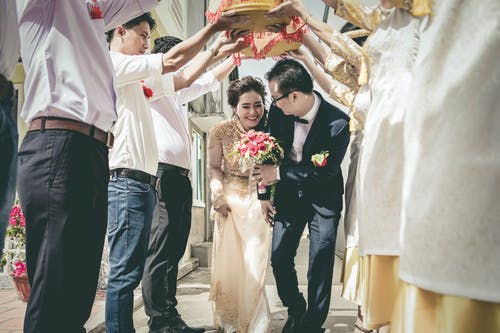 新娘和新郎在人站立之间走 · 免费素材图片