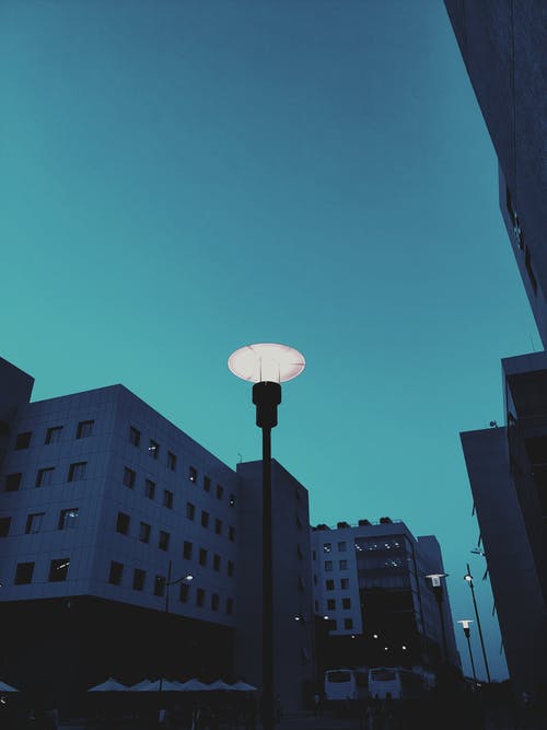 在傍晚的天空下点燃街边的灯柱 · 免费素材图片