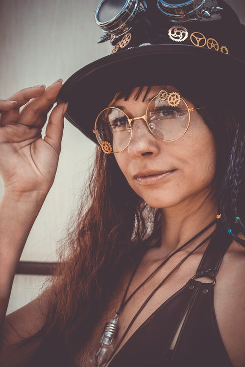 戴黑大礼帽的眼镜的女人的特写肖像照片 · 免费素材图片