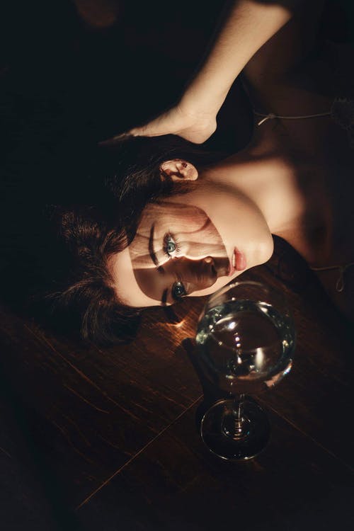 躺在透明酒杯旁边的女人 · 免费素材图片
