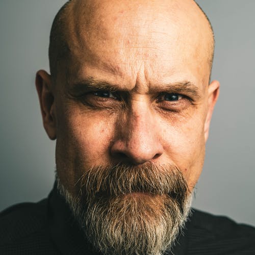 严肃的表情的秃头男人 · 免费素材图片