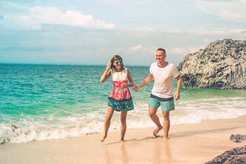 笑夫妻在海边散步的照片 · 免费素材图片