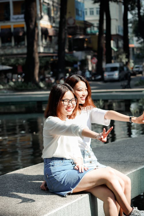 坐在混凝土砌块上的微笑妇女 · 免费素材图片