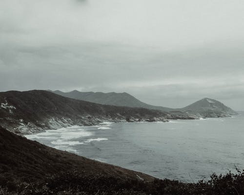 在灰色多云的天空下山俯瞰海滩 · 免费素材图片