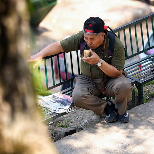男子坐在选择性聚焦摄影 · 免费素材图片