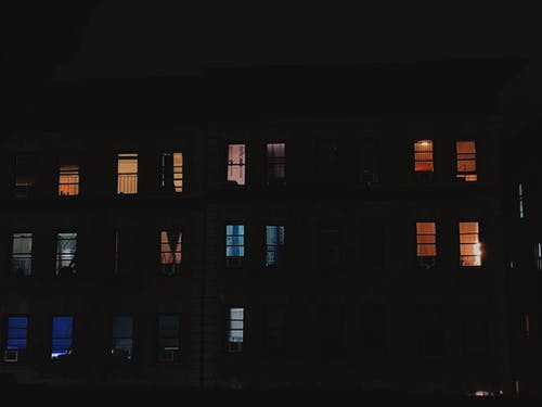 夜间开放式窗户的多层建筑 · 免费素材图片