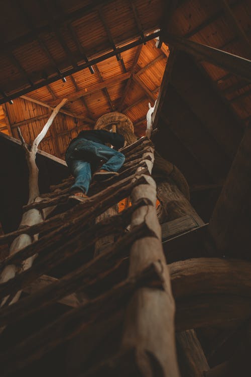 未知的人爬上棕色木梯 · 免费素材图片