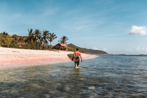 男子携带冲浪板照片 · 免费素材图片