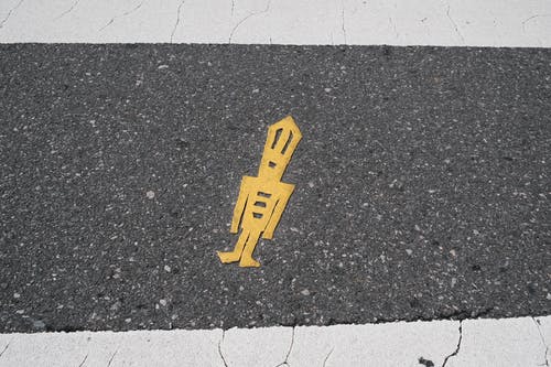在灰色的混凝土通路上的黄色贴纸 · 免费素材图片