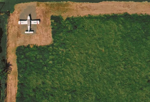 单翼飞机停在场附近 · 免费素材图片