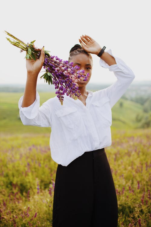 女人拿着紫色的花的照片 · 免费素材图片