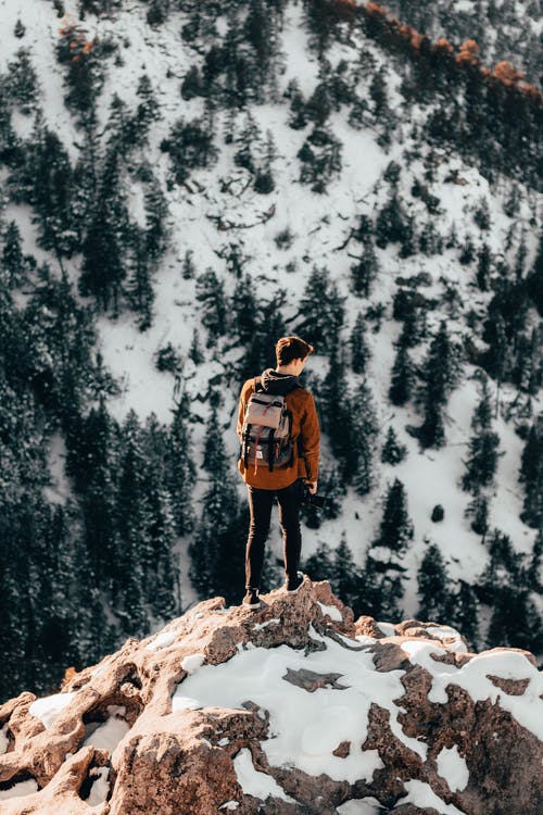 一个男人在雪山顶部的照片 · 免费素材图片