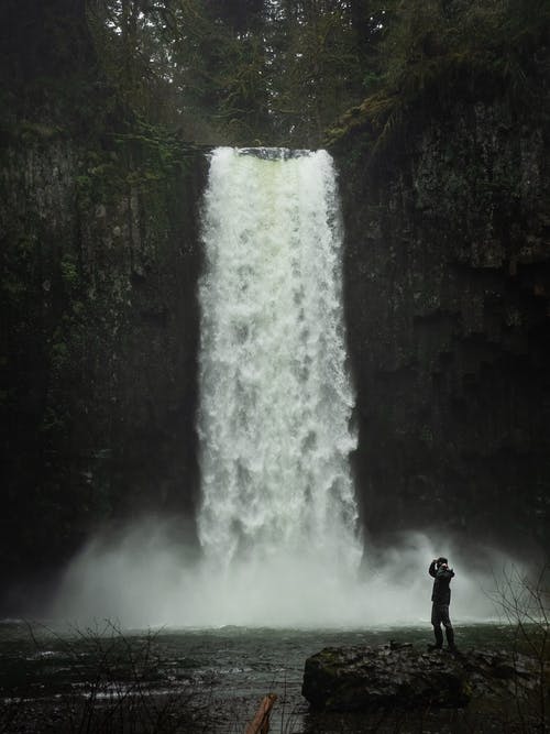 站在瀑布附近的人的照片 · 免费素材图片