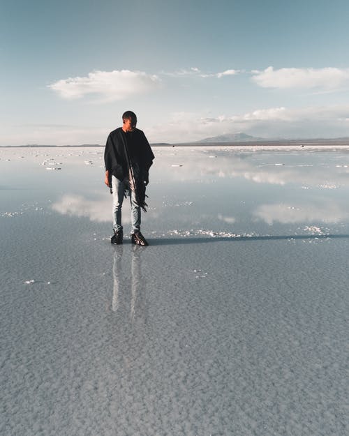 一个人站在退潮海底的照片 · 免费素材图片