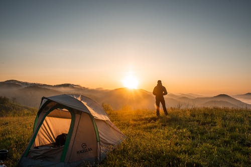 人站在露营帐篷附近的剪影 · 免费素材图片