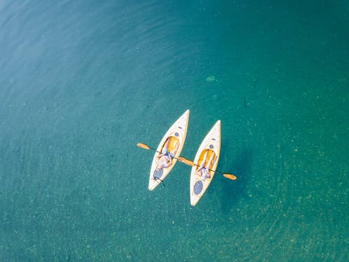 两人在水面上划独木舟的鸟瞰图 · 免费素材图片