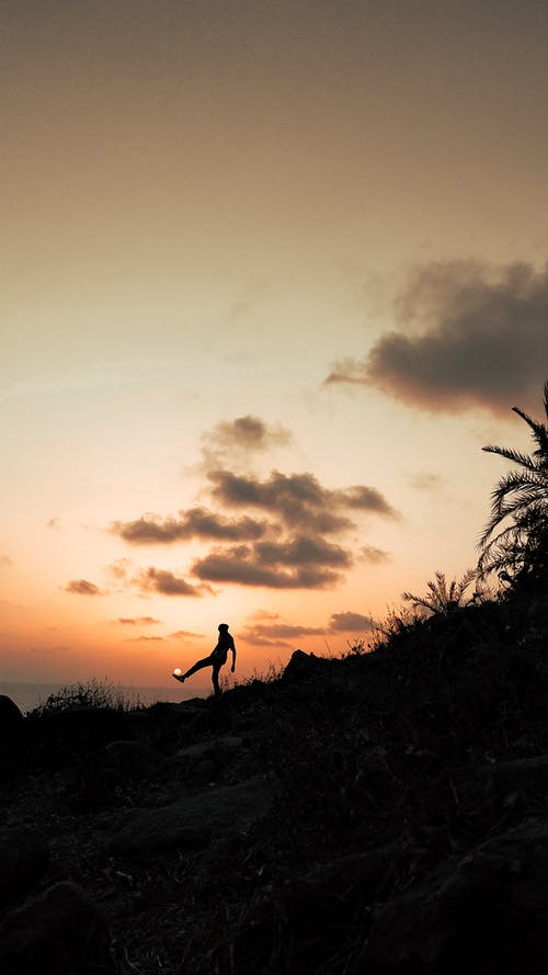 在夕阳的天空下踢太阳的匿名人士 · 免费素材图片