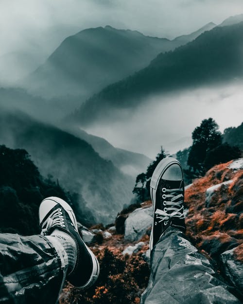男子坐在山崖上 · 免费素材图片
