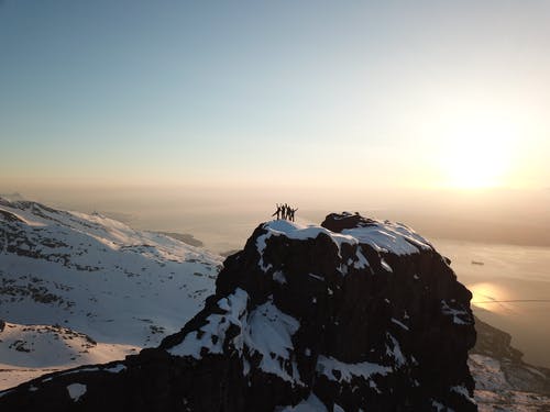 冰雪覆盖的山顶上的四个人 · 免费素材图片