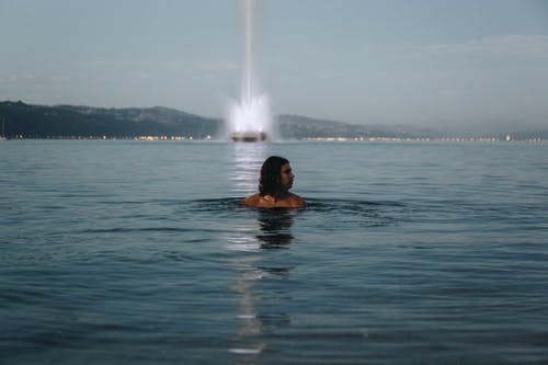男子游泳在水体中的照片 · 免费素材图片