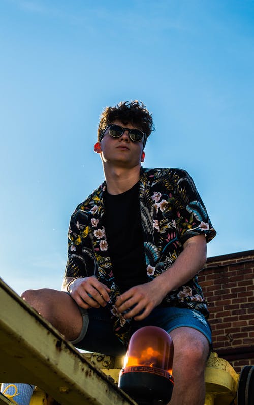 坐在蓝蓝的天空下的男人 · 免费素材图片