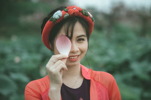 女人抱着粉红色和白色的花瓣 · 免费素材图片