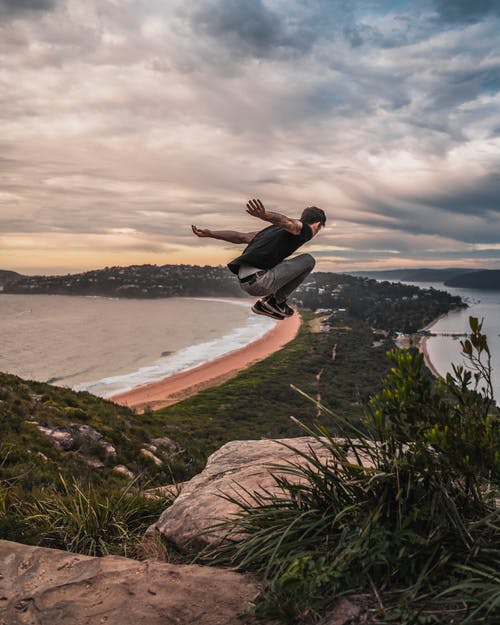 男子从山崖上跳下来的延时摄影 · 免费素材图片