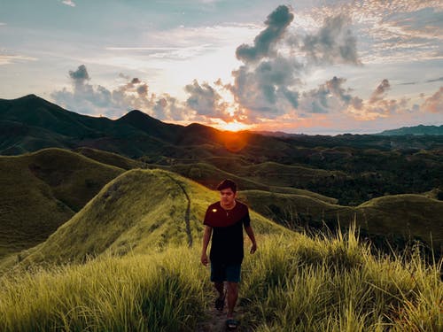 在日落时分走在草岭的人 · 免费素材图片