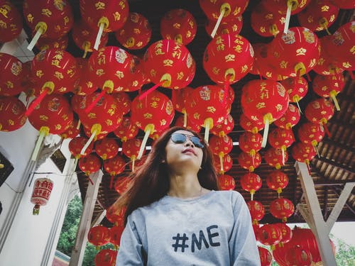 在红色中国灯笼下太阳镜的女人低角度照片 · 免费素材图片