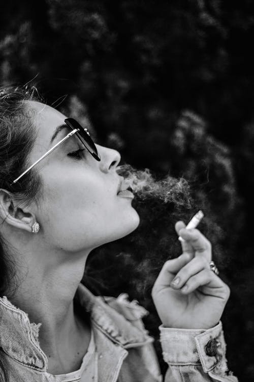 女人吸烟香烟的单色照片 · 免费素材图片