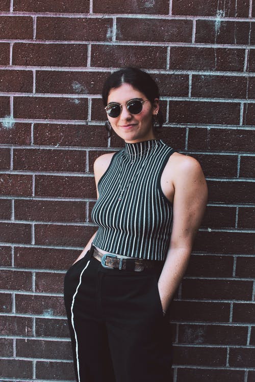 女人站在砖墙前的照片 · 免费素材图片