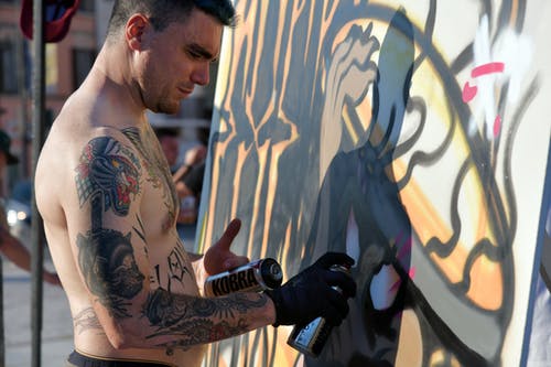 裸照纹身艺术家绘画墙的侧视图照片 · 免费素材图片