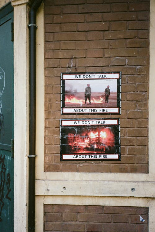建筑物的砖墙上的两个海报 · 免费素材图片