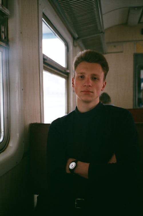 男子坐在火车上，双臂交叉的照片 · 免费素材图片