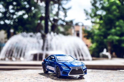 横跨室外喷泉的蓝色压铸玩具车 · 免费素材图片