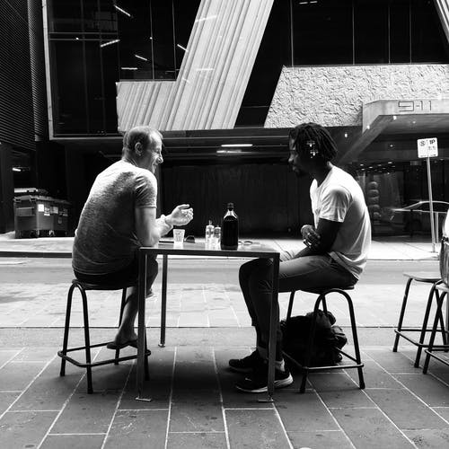 两名男子坐在椅子上聊天的照片 · 免费素材图片