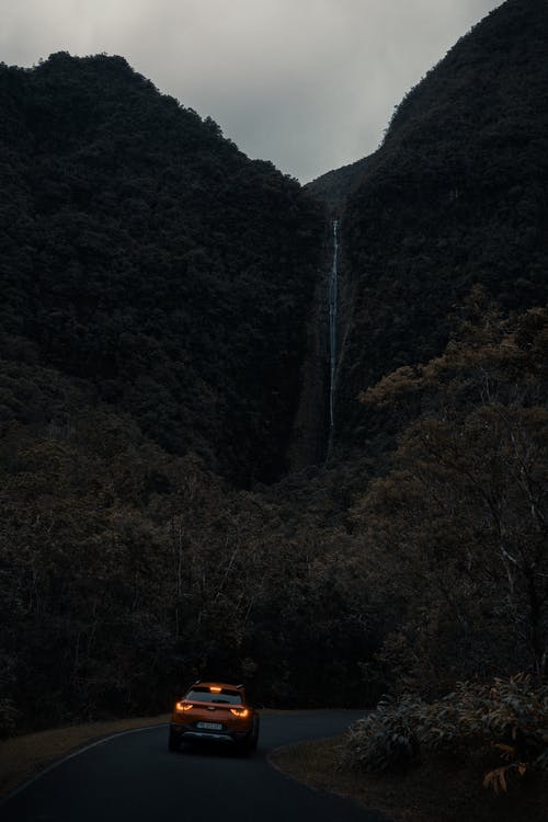 横跨瀑布的橙色车照片 · 免费素材图片