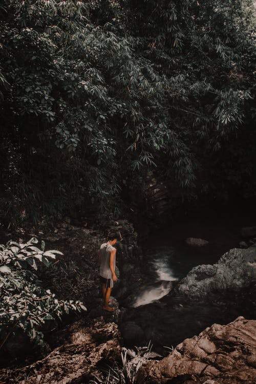 站在河边的岩石上的人的照片 · 免费素材图片