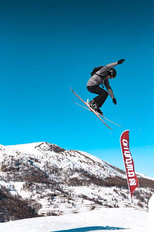 男子在空中做雪滑雪技巧 · 免费素材图片