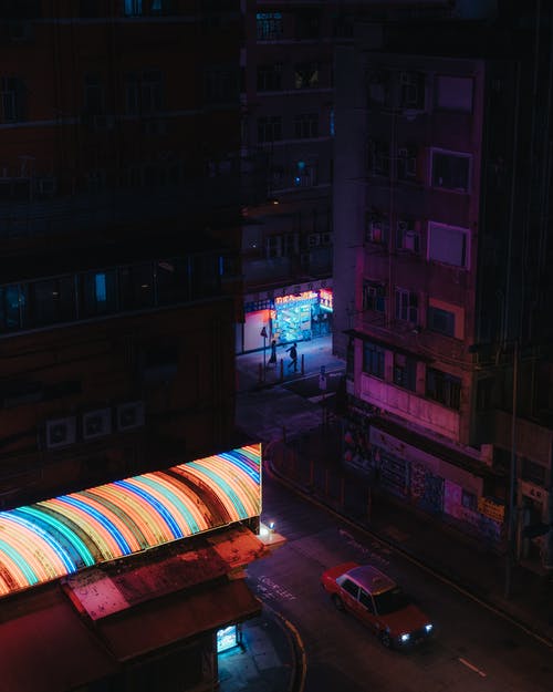 夜间在道路上行驶的红色汽车 · 免费素材图片